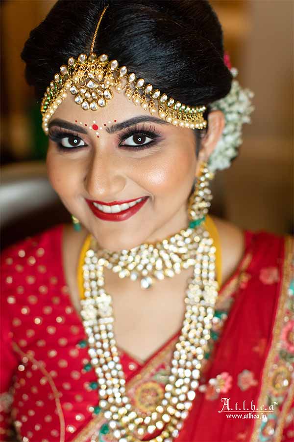 Close-up portrait of Bengali bride with traditional wedding jewelry and makeup