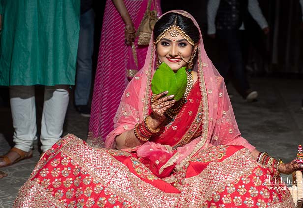 Bengali bride holding betel leaf during Shubho Drishti wedding ritual