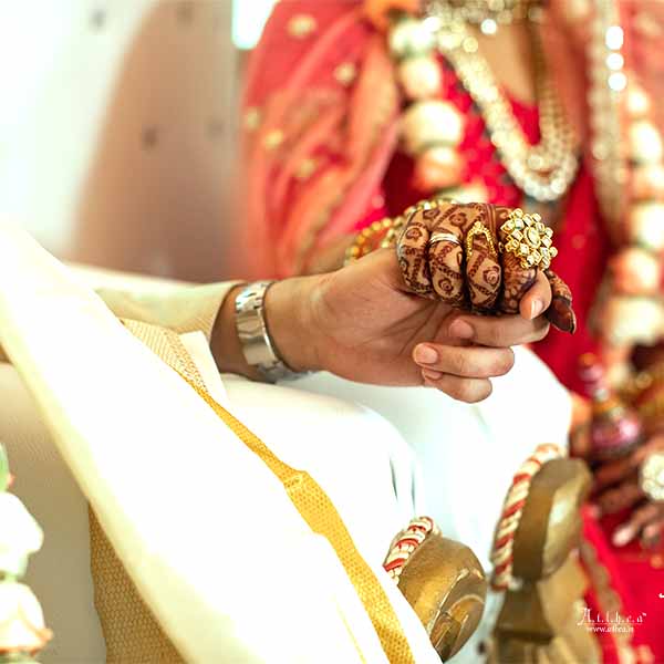 Close-up of bride and groom hands during traditional Bengali marriage ritual
