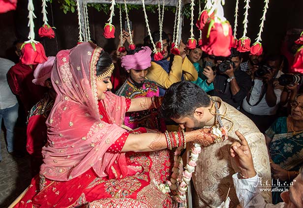 Bride and groom exchanging garlands during Mala Badol Bengali wedding ceremony