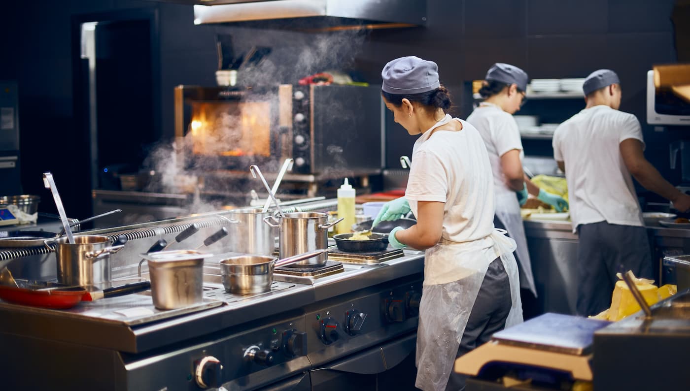 Professional catering kitchen setup with chefs preparing food for large event