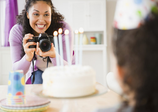 Professional photographer capturing joyful birthday party moments with children and family