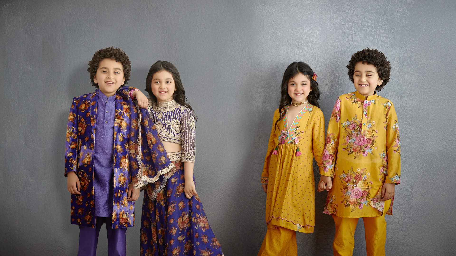 Children dressed in elegant traditional Indian wedding outfits posing at wedding ceremony
