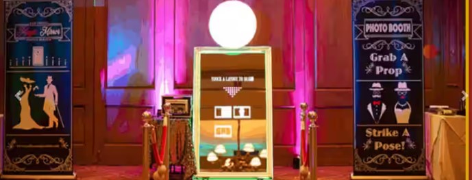 Couple enjoying a decorated photo booth at a Chennai wedding reception with floral backdrop