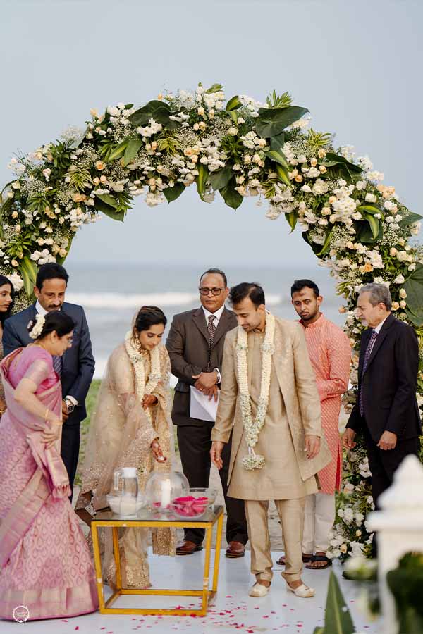 Beach wedding varmala ceremony with floral arch decor in Chennai
