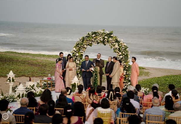 Guests seated at beach wedding during varmala ceremony