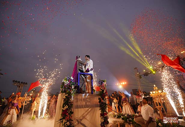 Groom lifted during energetic varmala celebration with fireworks