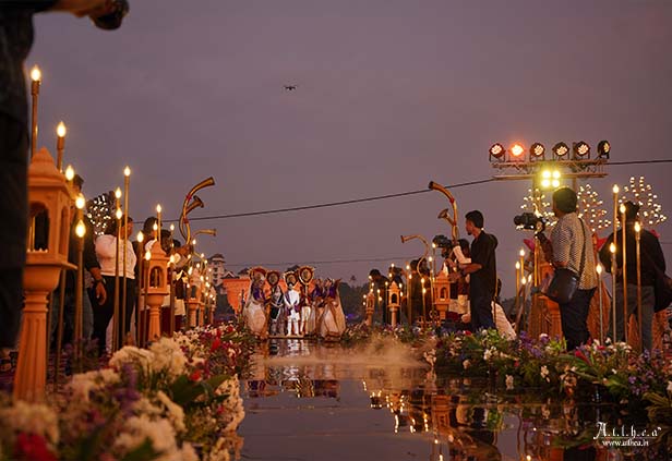 Evening varmala ceremony with decorative lights and floral stage