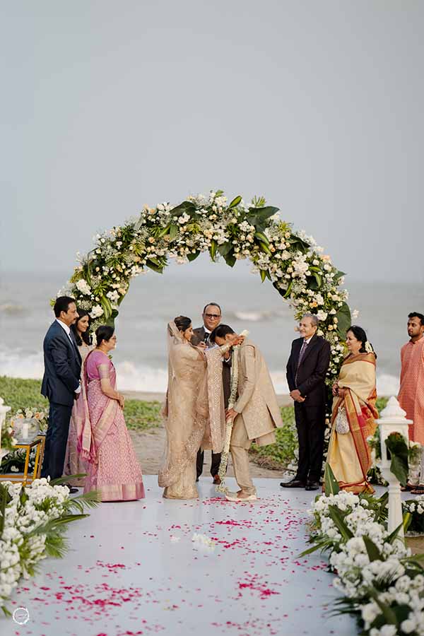 Couple exchanging varmala on decorated stage with flower shower